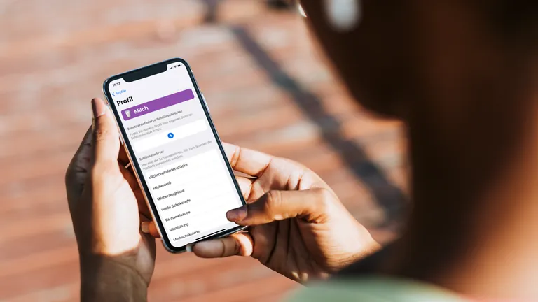 Hands holding a phone with a milk allergy profile and its keyword list